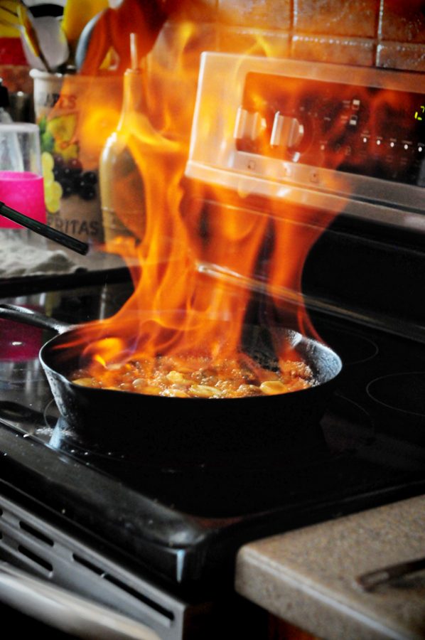 Cast iron skillet on stove with flaming bananas.
