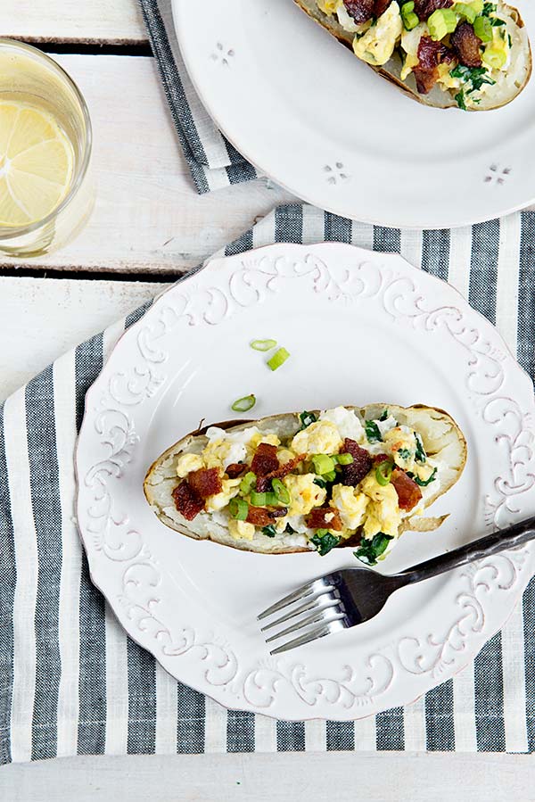 Downward view of twice baked breakfast potatoes on a striped napkin and white plate